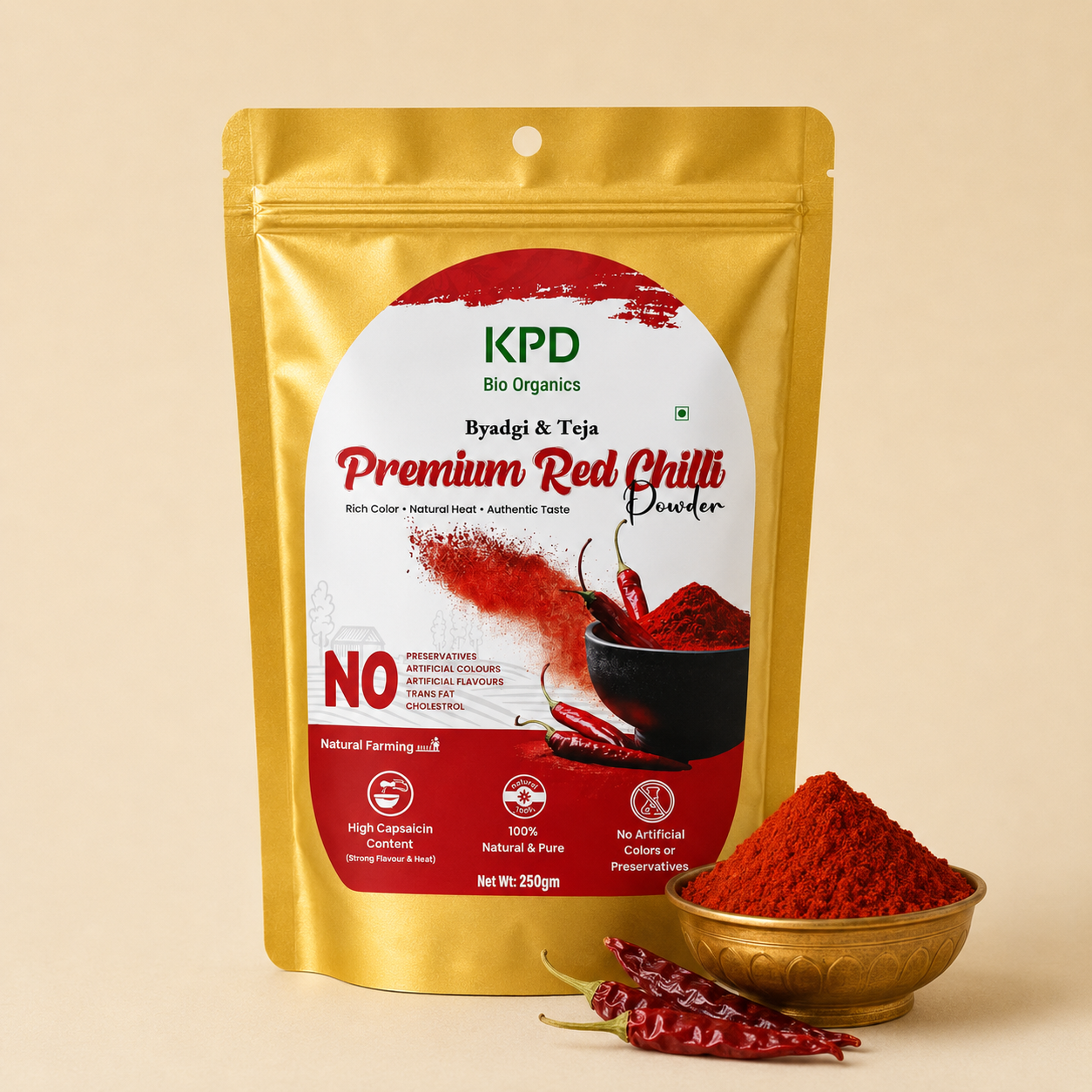 KPD Bio Organics Premium Red Chilli powder pouch beside a brass bowl heaped with chilli powder